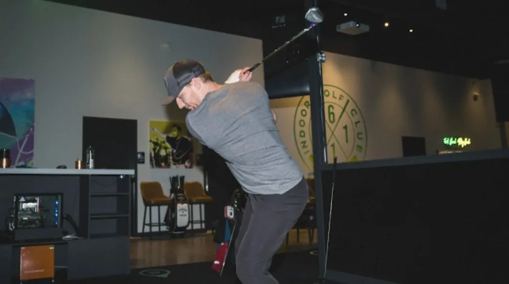 Drop hero photo — member mid-swing in a bay